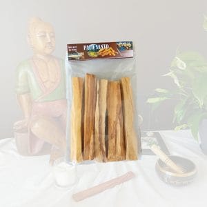 Un paquet de Palo Santo sur un arrière plan avec une image zen. Ce paquet de bois sacré est composé de plusieurs bâtons à bruler pour nettoyer les énergies.