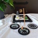 Ensemble de portes encens noirs ronds dans une atmosphère apaisante. Ils sont en pierre et peuvent être utilisés avec des bâtonnets ou des cônes simples d'encens. Ils ont des motifs zen dans un design minimaliste et élégant.