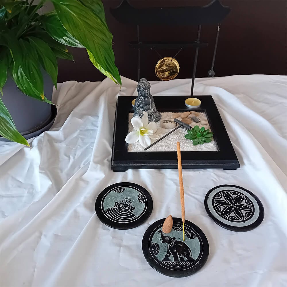 Ensemble de portes encens noirs ronds dans une atmosphère apaisante. Ils sont en pierre et peuvent être utilisés avec des bâtonnets ou des cônes simples d'encens. Ils ont des motifs zen dans un design minimaliste et élégant.