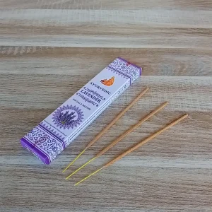 Image de l'encens Ayurvedic Lavande en bâtonnets. Cette boite d'encens est posée sur un fond zen. Il y a 3 bâtonnets d'encens posés à côté. Cette fragrance est en vente chez Zen Aatma - boutique zen et ésotérique.