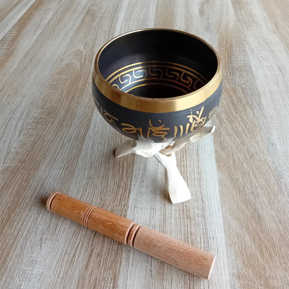 Image d'un bol chantant tibétain sur un trépied Cobra naturel. Objet d'épanouissement personnel idéal pour la méditation, la relaxation et les soins énergétiques le bol chantant tibétain est disponible en 3 tailles : moyen, grand et très grand. Il émet des vibrations sonores harmonieuses grâce à son bâton spécial. Disponible chez Zen Aatma - boutique zen et ésotérique.