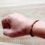 Image du bracelet en pierres d'œil de tigre porté au poignet. Discret, raffiné et énergétiquement puissant, ce bracelet en perles d’œil de tigre de 4 mm est un véritable concentré de protection et d’ancrage. Ce bracelet élastique est en vente chez Zen Aatma - boutique zen et ésotérique.