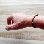 Image du bracelet en pierres d'œil de tigre porté au poignet. Discret, raffiné et énergétiquement puissant, ce bracelet en perles d’œil de tigre de 4 mm est un véritable concentré de protection et d’ancrage. Ce bracelet élastique est en vente chez Zen Aatma - boutique zen et ésotérique.