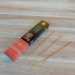 Image de l'encens Tribal Soul Copal blanc en bâtonnets. Cette boite d'encens est posée sur un fond zen. Il y a 3 bâtonnets d'encens posés à côté. Cette fragrance est en vente chez Zen Aatma - boutique zen et ésotérique.