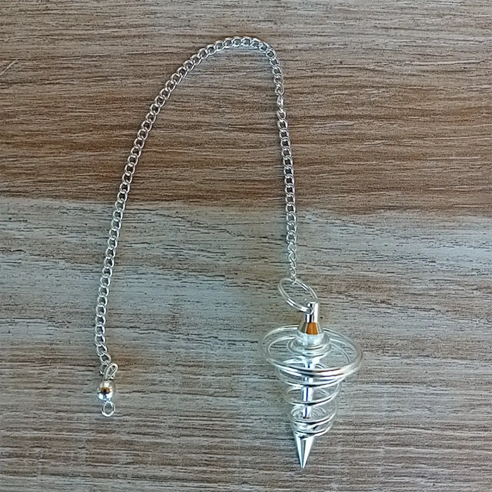 Image du pendule spirale argentée en vente chez Zen Aatma. Fourni avec une chainette en métal de 16 cm de long, il est idéal pour la divination, les soins énergétiques et les tests vibratoires - Zen Aatma boutique zen et ésotérique.